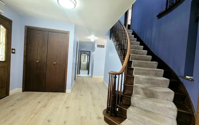 a view of hallway with wooden floor and stairs