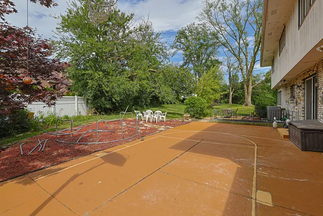 a view of a yard with basketball court