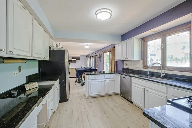 a kitchen with a sink cabinets stainless steel appliances and a window