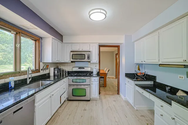 a kitchen with stainless steel appliances a sink a stove a microwave and cabinets