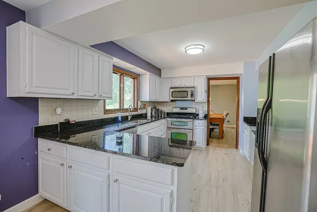 a kitchen with a refrigerator and a stove top oven