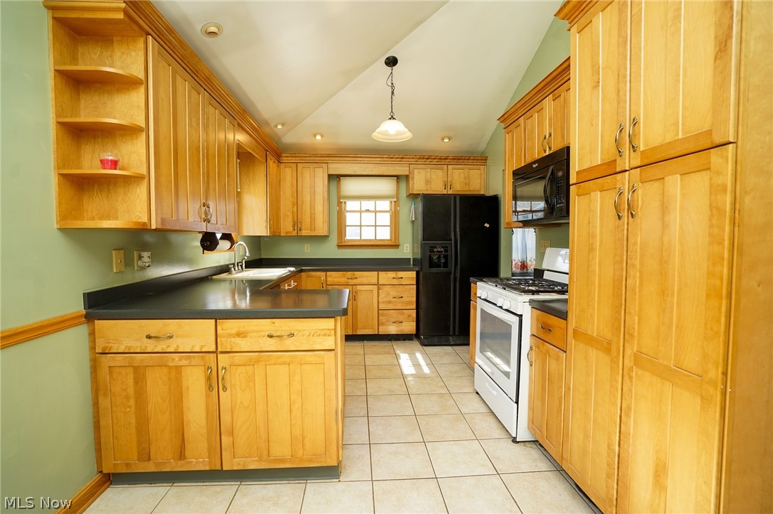 453 Omar Street Struthers, OH 44471 - Photo 11 of 27 Kitchen with black appliances, vaulted ceiling, open shelves, a peninsula, and light tile patterned flooring