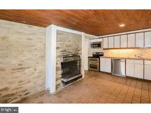 a kitchen with stainless steel appliances granite countertop a stove top oven a sink and a refrigerator