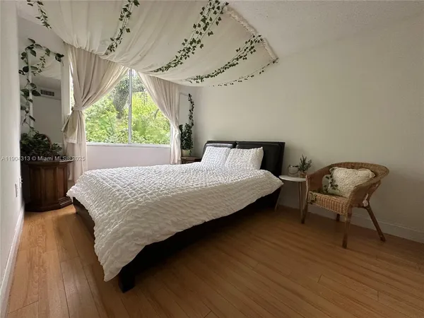 a bedroom with a bed chair and window