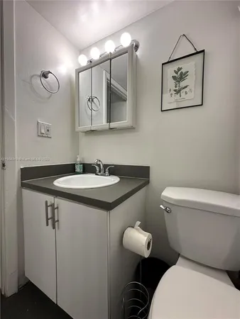 a bathroom with a toilet sink and mirror