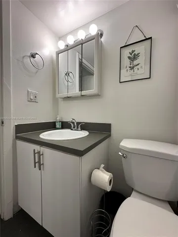 a bathroom with a toilet sink and mirror