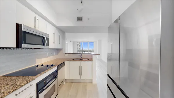 a kitchen with a sink and steel appliances
