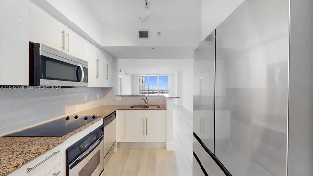 a kitchen with a sink and steel appliances