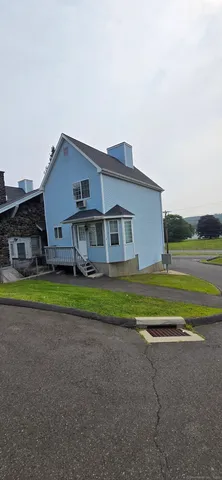 a house view with a big yard plants and large trees