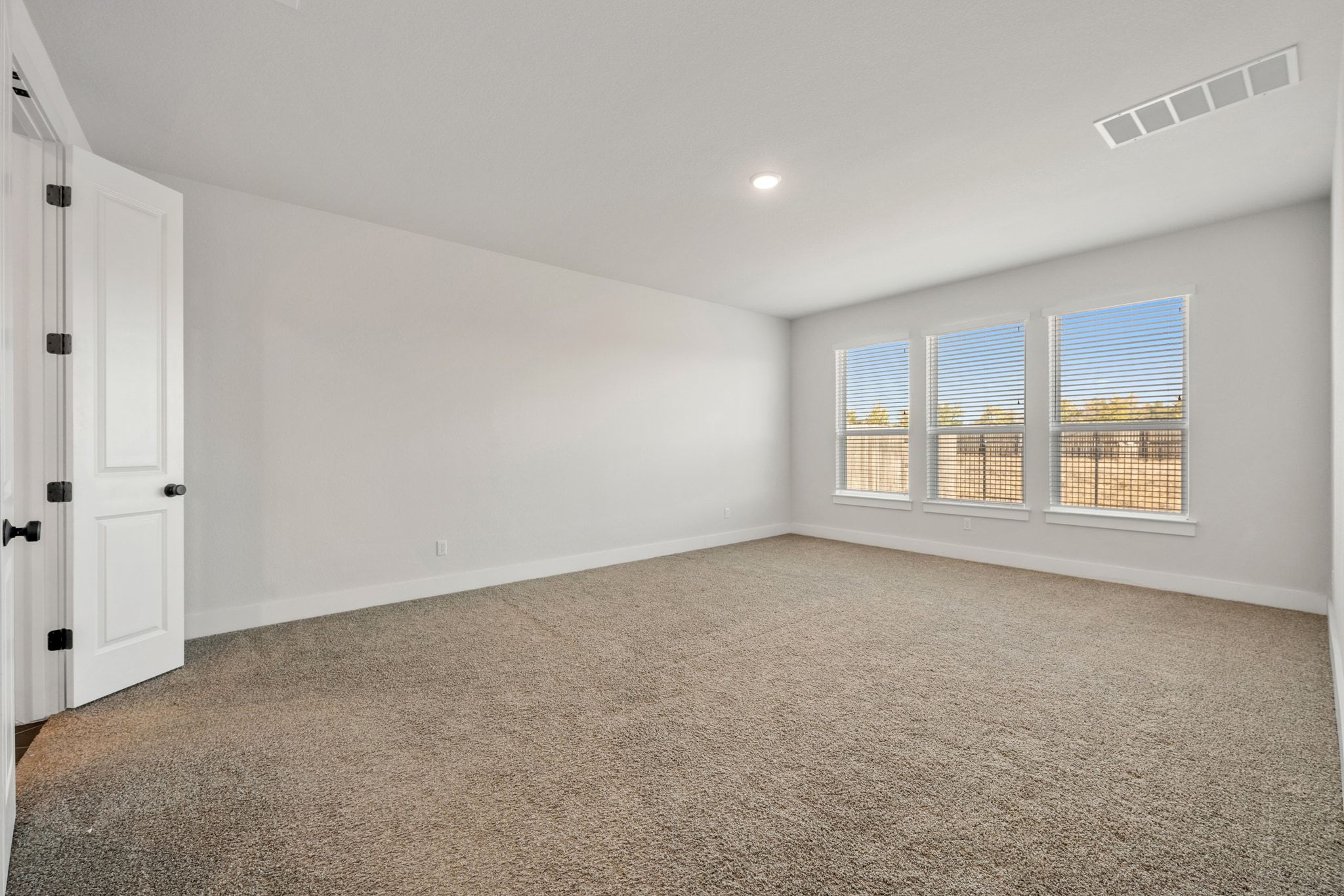957 Arrowhead Ranch Boulevard Dripping Springs, TX 78620 - Photo 10 of 31 Spacious primary bedroom with windows overlooking private backyard.