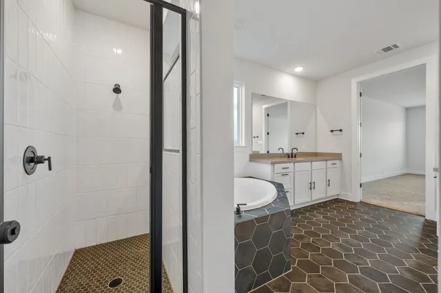 a bathroom with a granite countertop sink a mirror and a shower