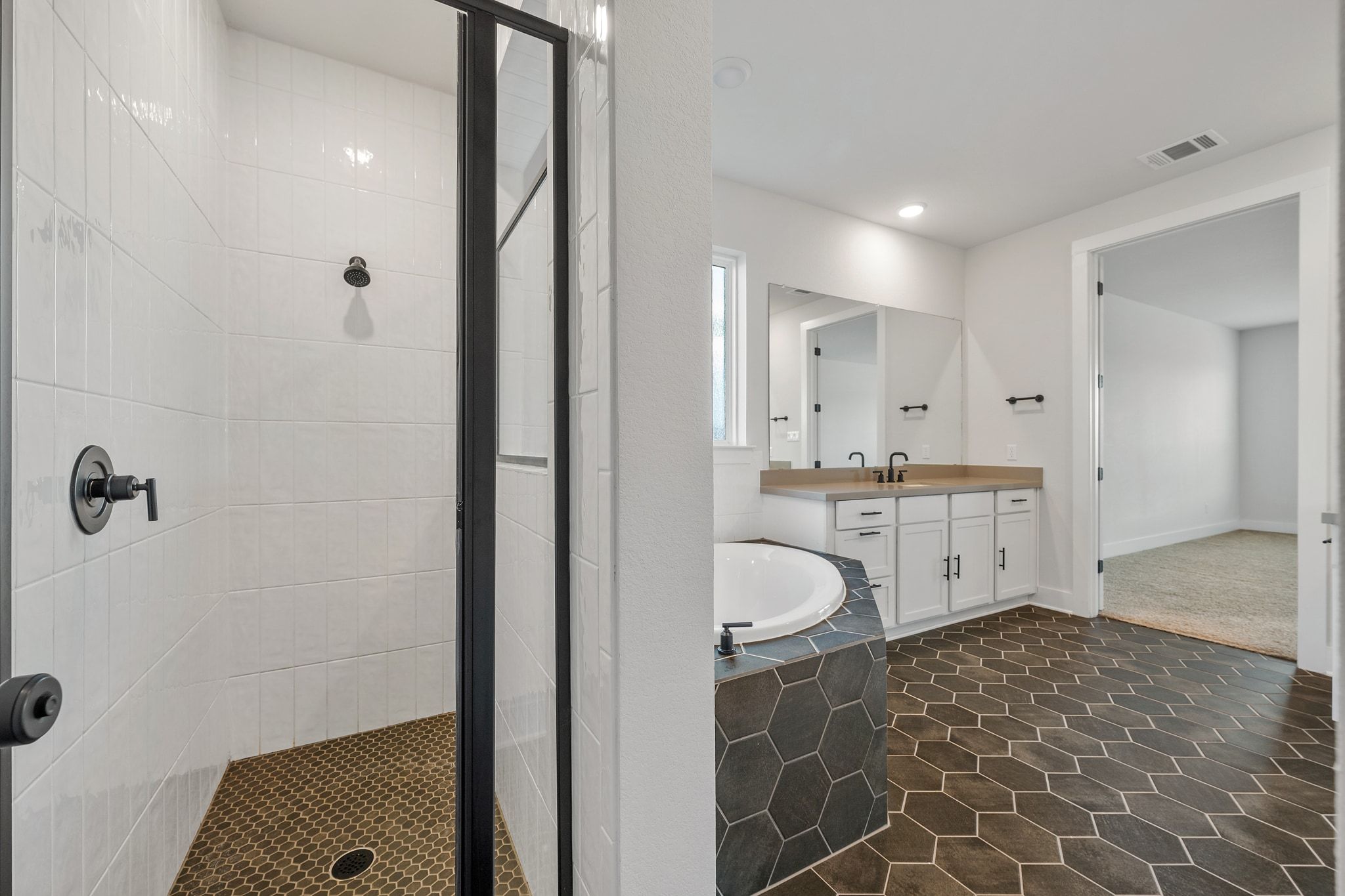 957 Arrowhead Ranch Boulevard Dripping Springs, TX 78620 - Photo 12 of 31 Full bathroom with a large soaking tub, dual vanities, separate shower, and walk-in closet.