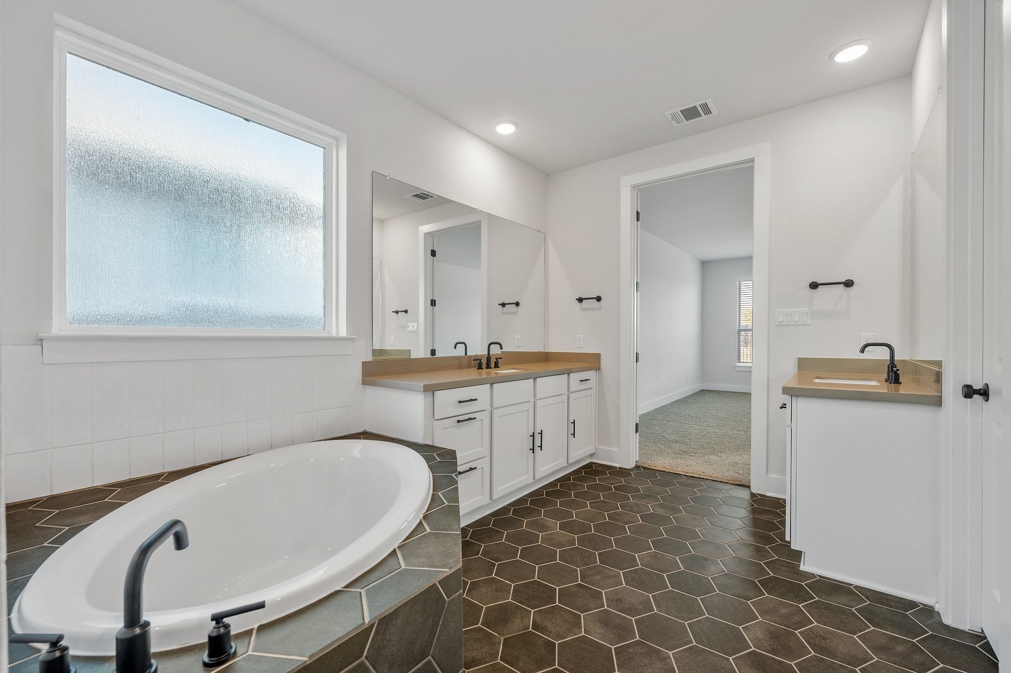 957 Arrowhead Ranch Boulevard Dripping Springs, TX 78620 - Photo 13 of 31 Bathroom featuring two vanities, a bath, and recessed lighting