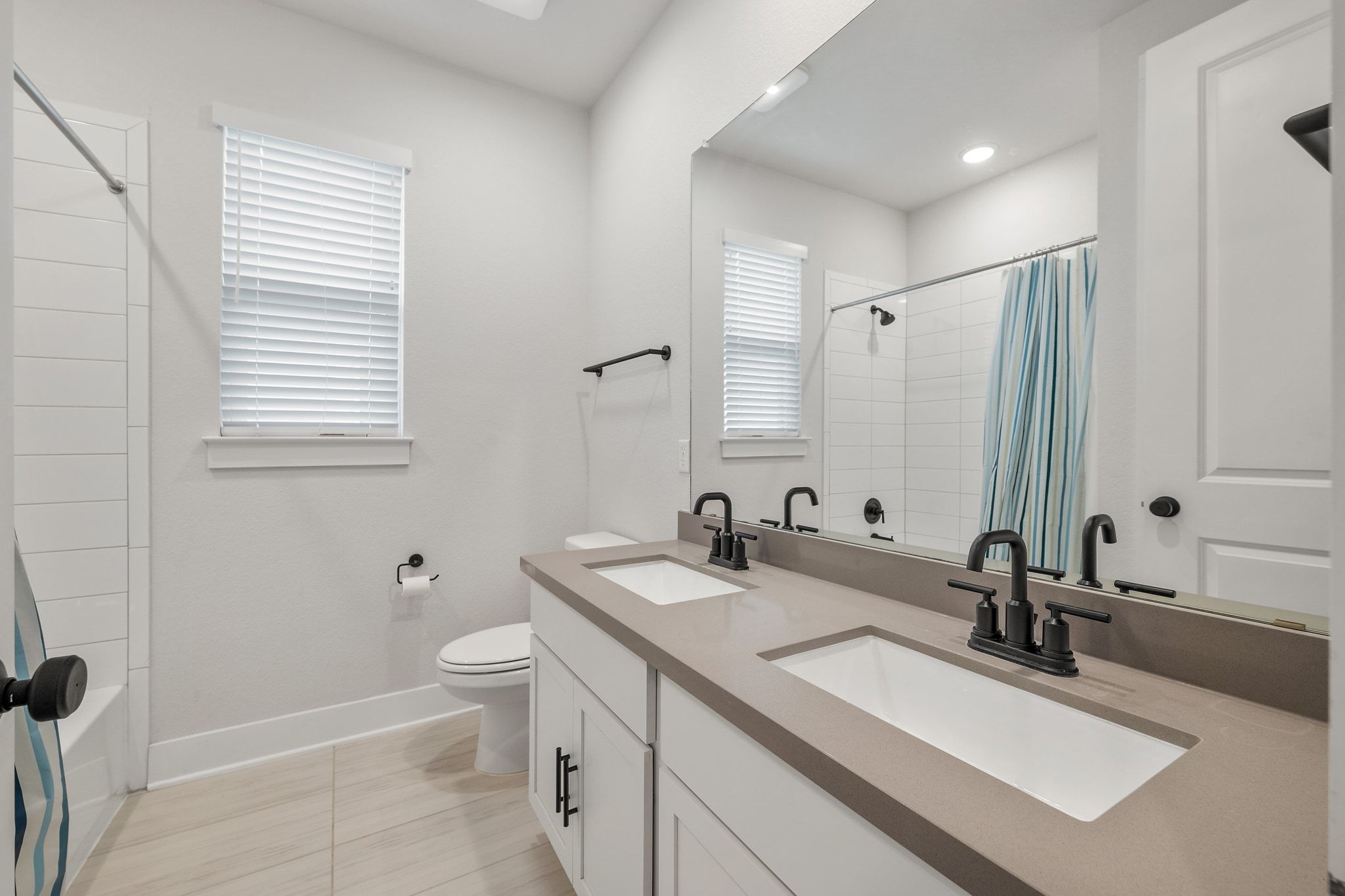 957 Arrowhead Ranch Boulevard Dripping Springs, TX 78620 - Photo 19 of 31 Full bath with double vanity, shower / bath combo with shower curtain, and light tile patterned flooring