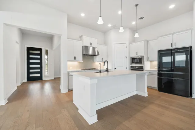 a large kitchen with cabinets and stainless steel appliances