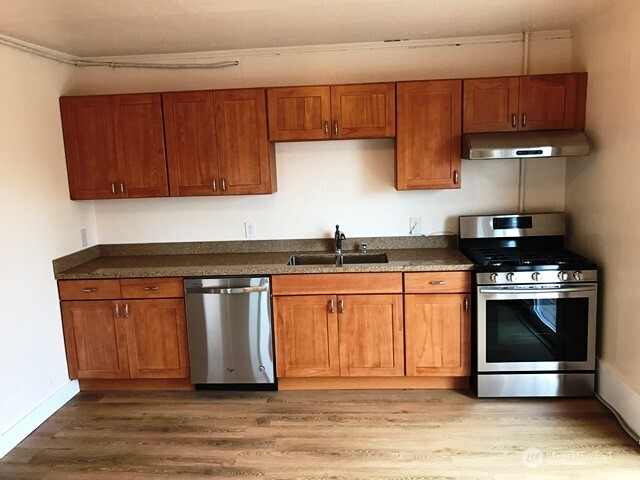 1920 East Jefferson Street, Unit B Seattle, WA 98122 - Photo 3 of 9 a kitchen with stainless steel appliances granite countertop a stove a sink and a microwave