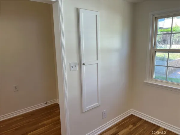 an empty room with wooden floor and a window