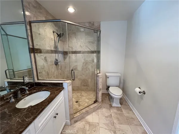 a bathroom with a granite countertop sink toilet and shower