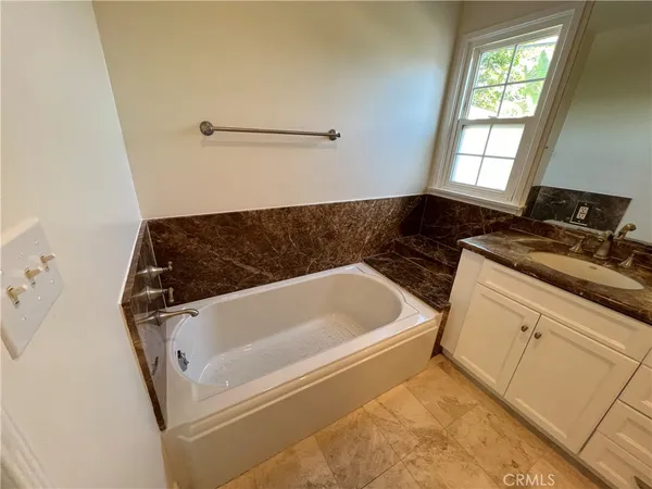 a bathroom with a tub sink and window