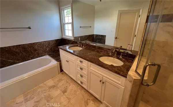 a bathroom with a tub sink and mirror