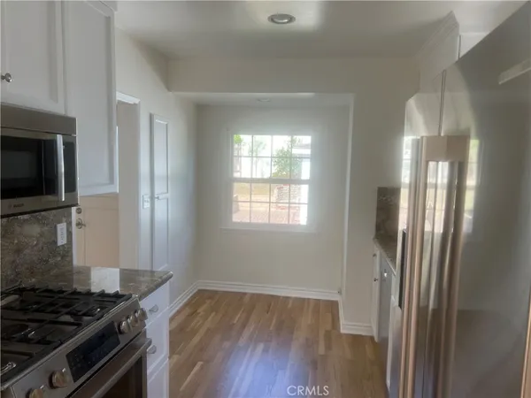 a kitchen that has a stove and a wooden floor
