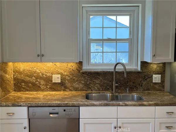 a kitchen with granite countertop a sink and a window