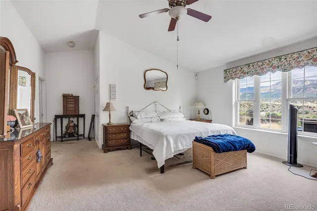 a spacious bedroom with a bed and a chandelier