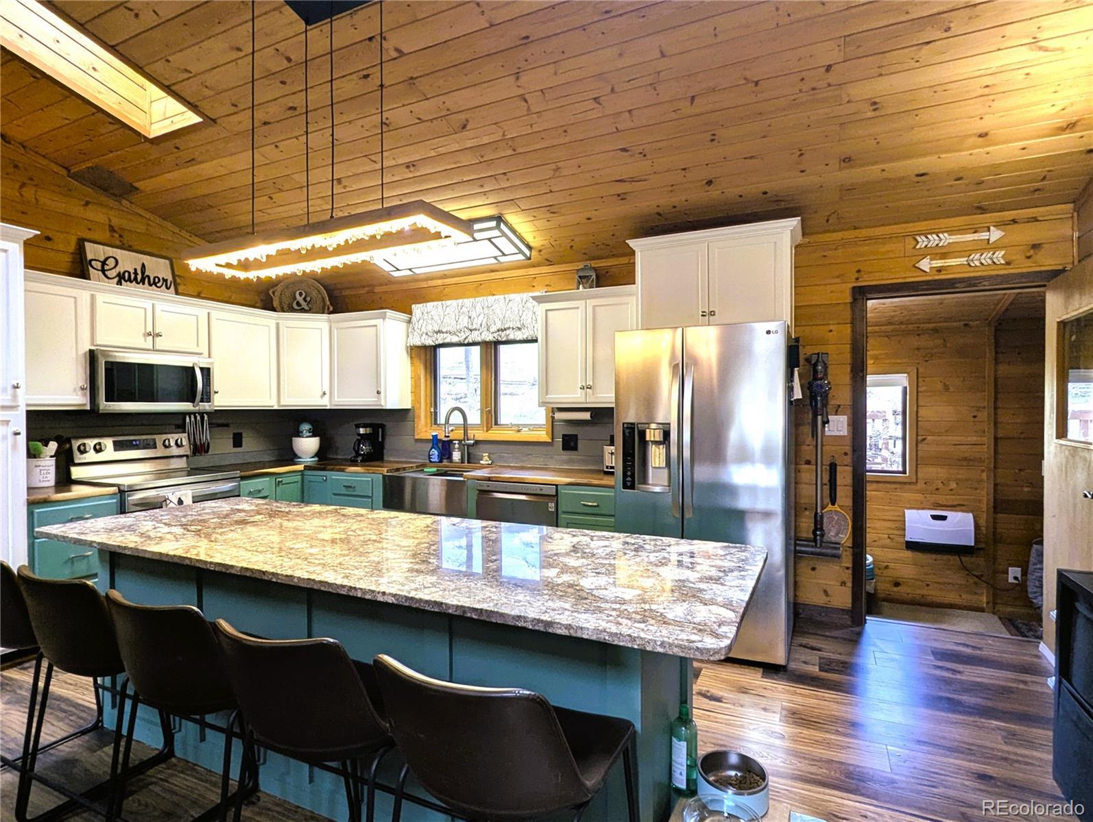 2084 Forbes Park Road Fort Garland, CO 81133 - Photo 21 of 39 a kitchen with granite countertop a table chairs sink and wooden cabinets