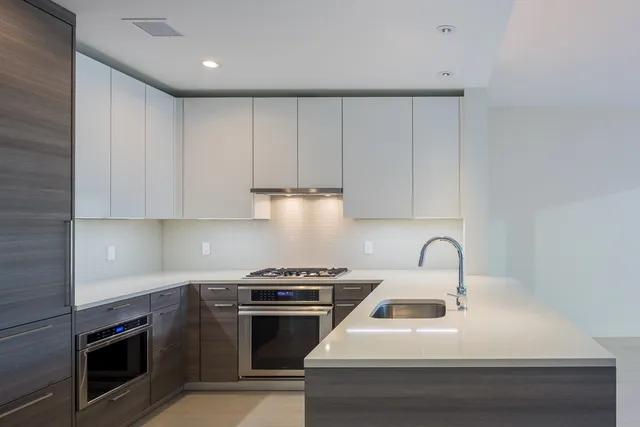 a kitchen with white cabinets and stainless steel appliances