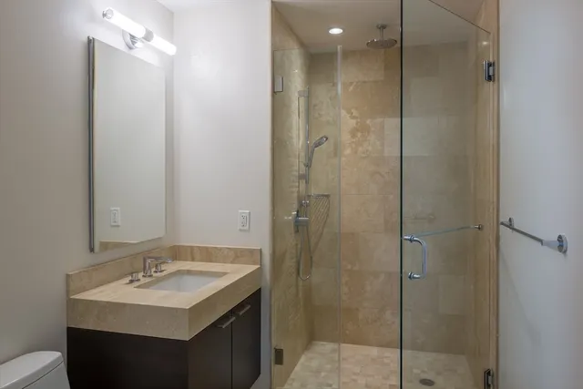 a bathroom with a sink a toilet and shower