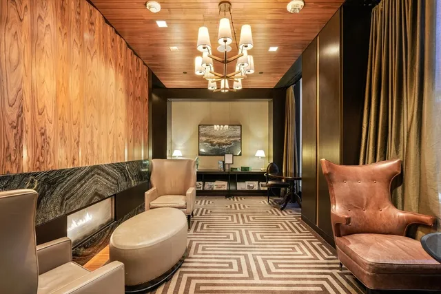 a living room with furniture a chandelier and a rug