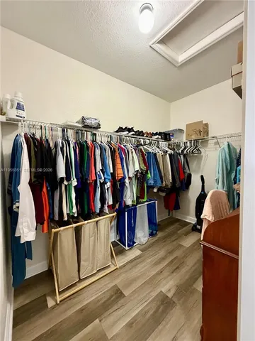 a view of walk in closet with clothes and shoes