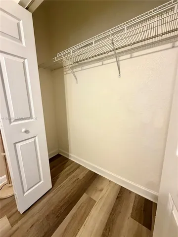 a view of walk in closet with empty racks