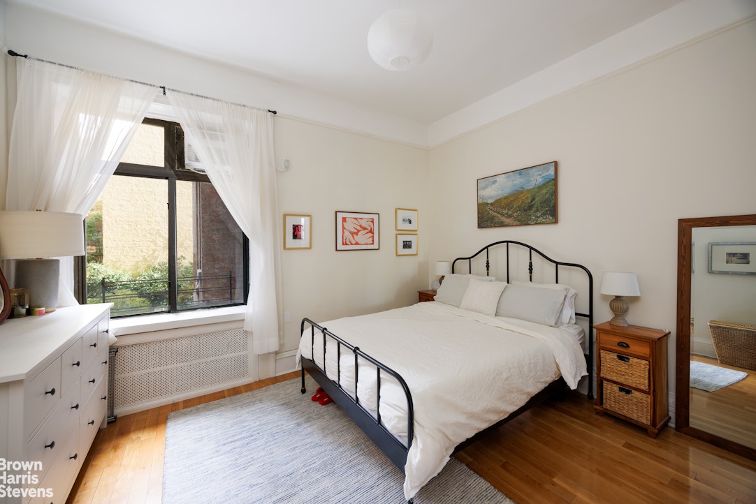 292 Riverside Drive, Unit 3A Manhattan, NY 10025 - Photo 5 of 11 a bedroom with a bed a large window with table and chair