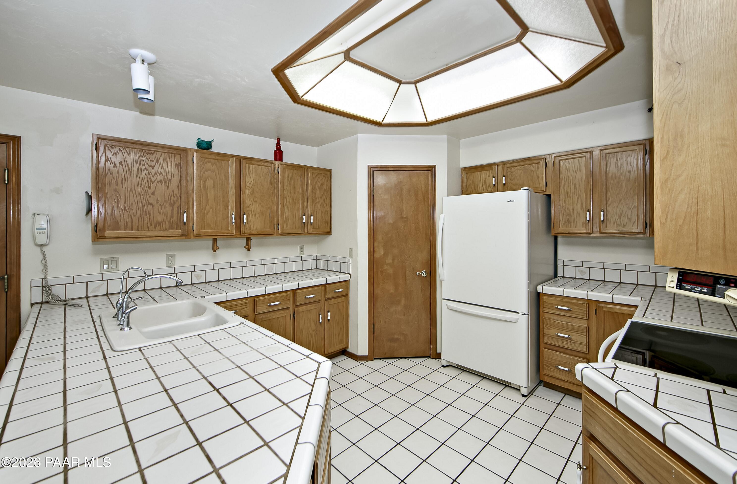 305 Ridge Court Prescott, AZ 86303 - Photo 10 of 35 a kitchen with granite countertop a refrigerator a stove top oven a sink and dishwasher