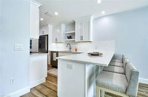 a kitchen with stainless steel appliances granite countertop a refrigerator sink and stove