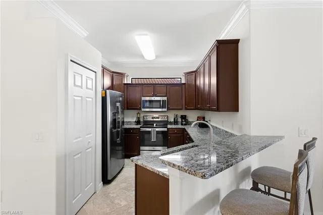 a kitchen with stainless steel appliances granite countertop a stove top oven a refrigerator a sink and dishwasher