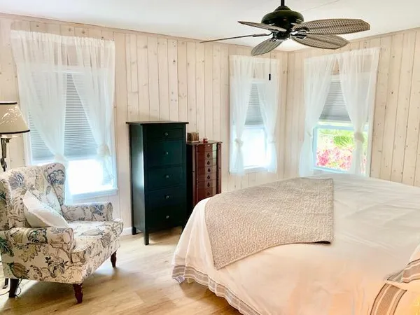 a view of a white house with a yard and a large tree