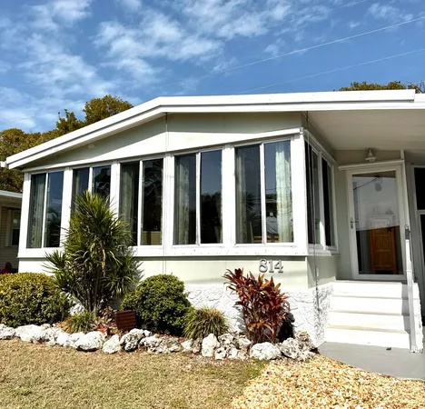 a kitchen with granite countertop a stove a sink and white cabinets