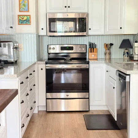 a kitchen with stainless steel appliances granite countertop a sink and a refrigerator