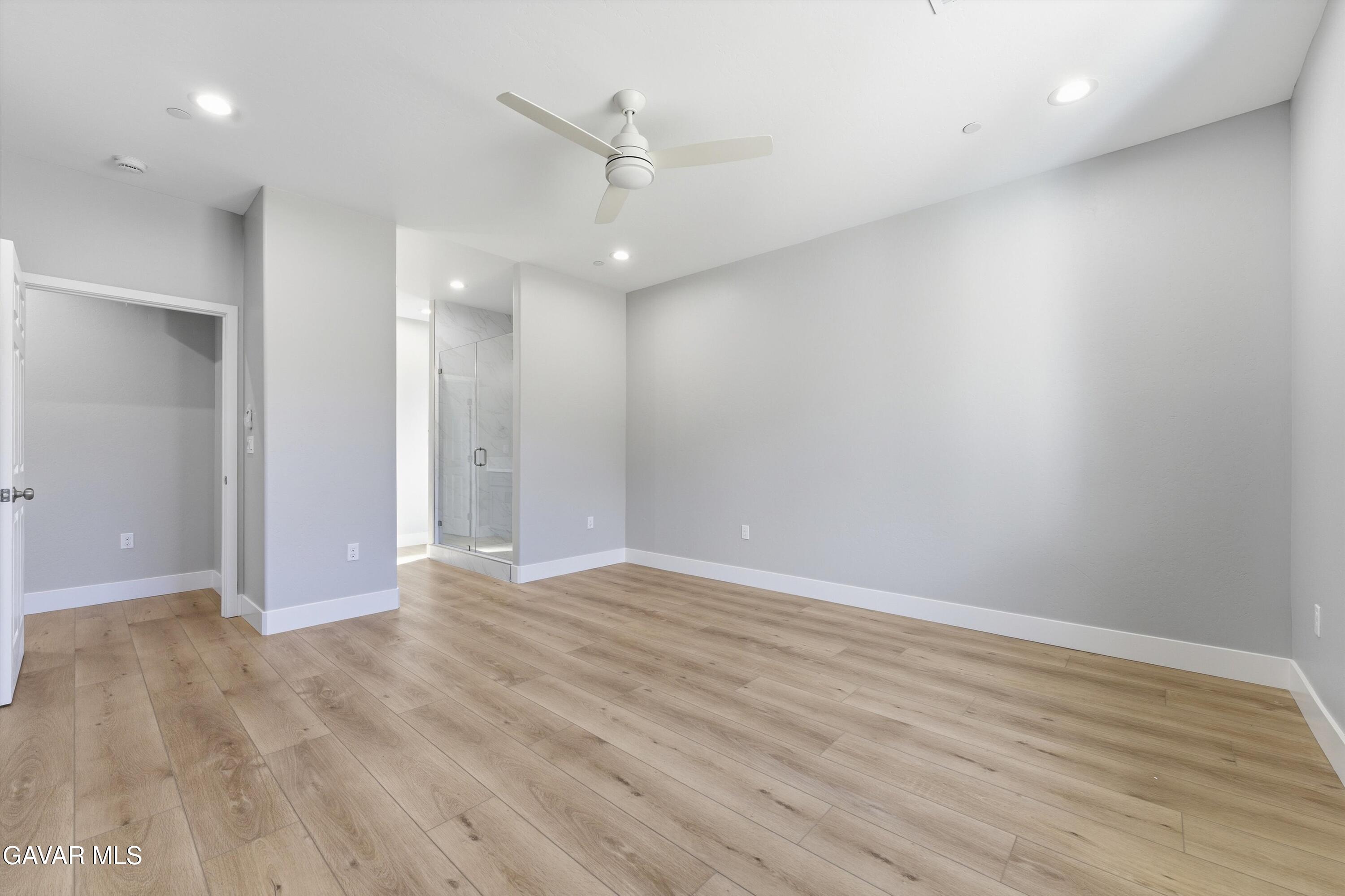 22613 Royal Place Tehachapi, CA 93561 - Photo 13 of 26 an empty room with wooden floor and ceiling fan