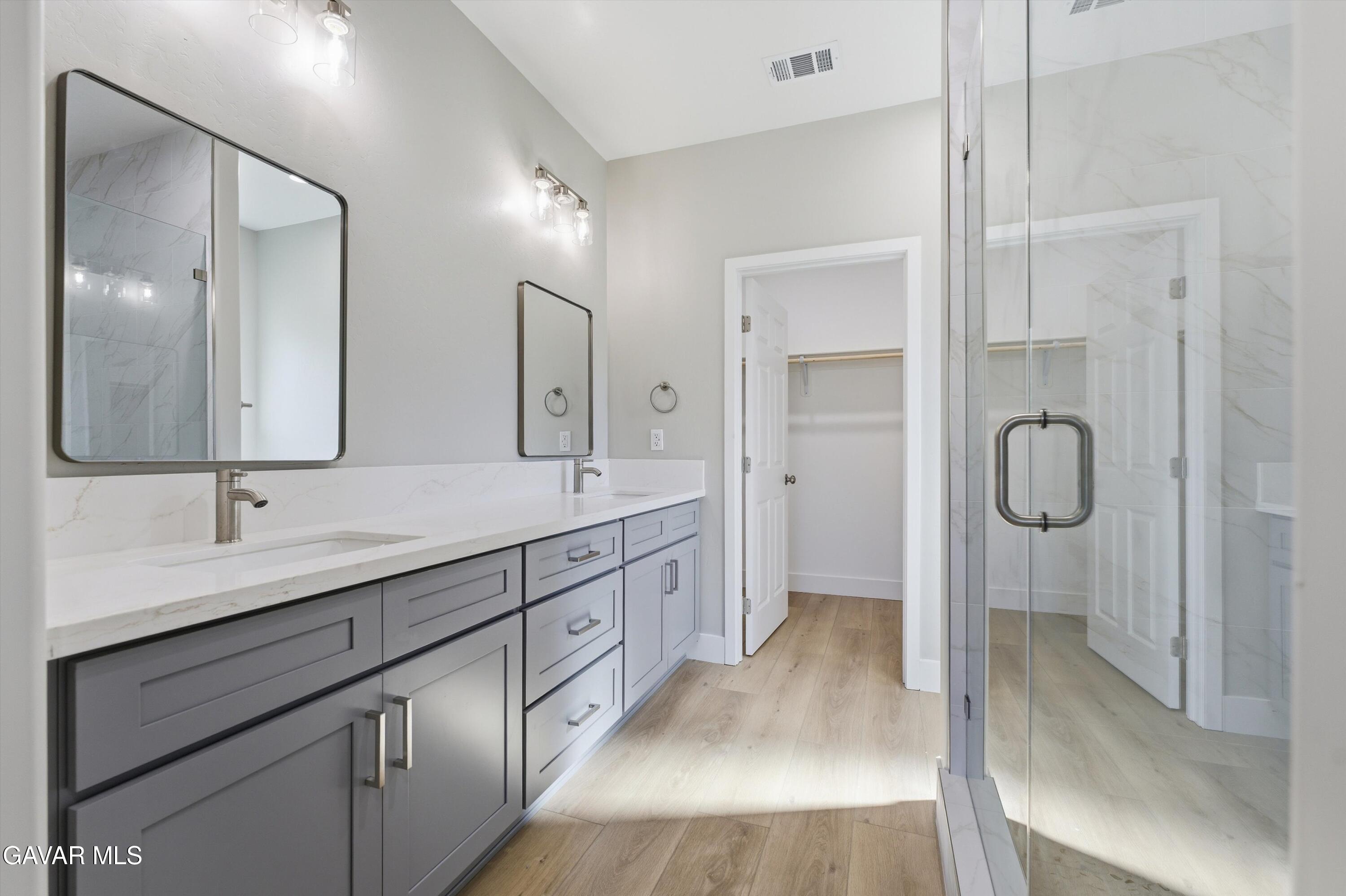 22613 Royal Place Tehachapi, CA 93561 - Photo 18 of 26 a spacious bathroom with a double vanity sink mirror double and shower
