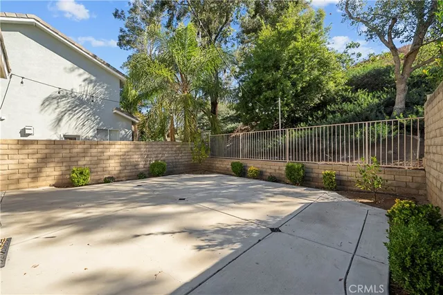 a view of backyard with wooden fence and trees