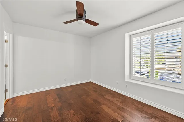 a view of empty room with window and ceiling fan