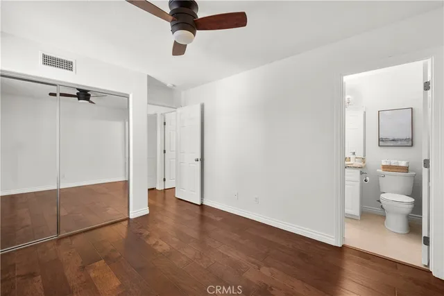 a view of a room with wooden floor cabinet and a bathroom