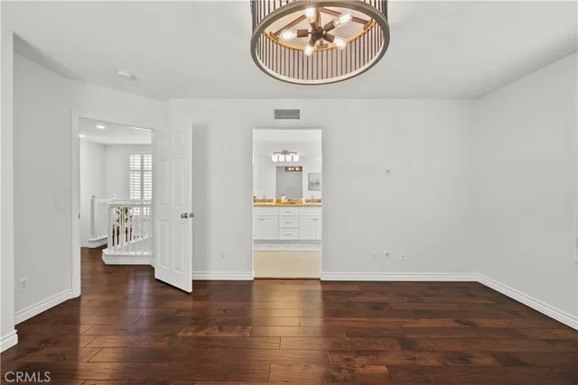 an empty room with wooden floor and mirror