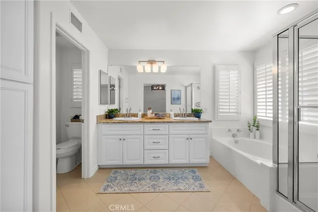 a spacious bathroom with a tub sink and mirror