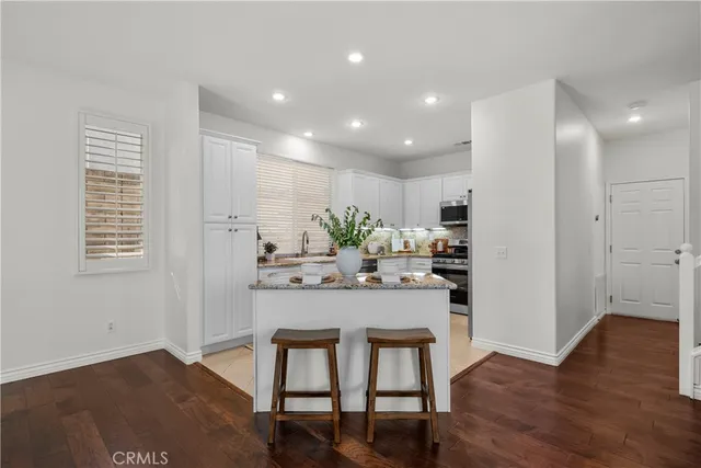 a kitchen with kitchen island white cabinets and stainless steel appliances