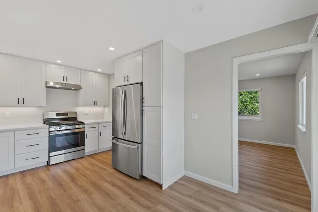 a kitchen with wooden floors and stainless steel appliances