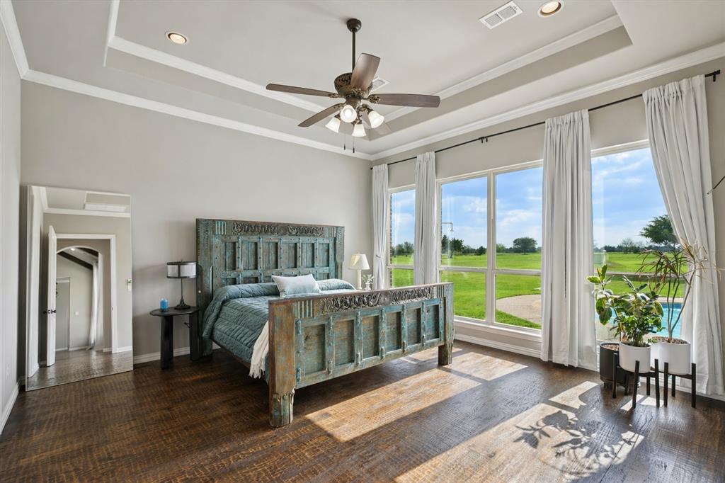 542 Pierce Road Red Oak, TX 75154 - Photo 6 of 27 Expansive windows with outdoor scenery, tray ceiling with recessed lighting and ceiling fan, wood-finish flooring, and light-toned walls